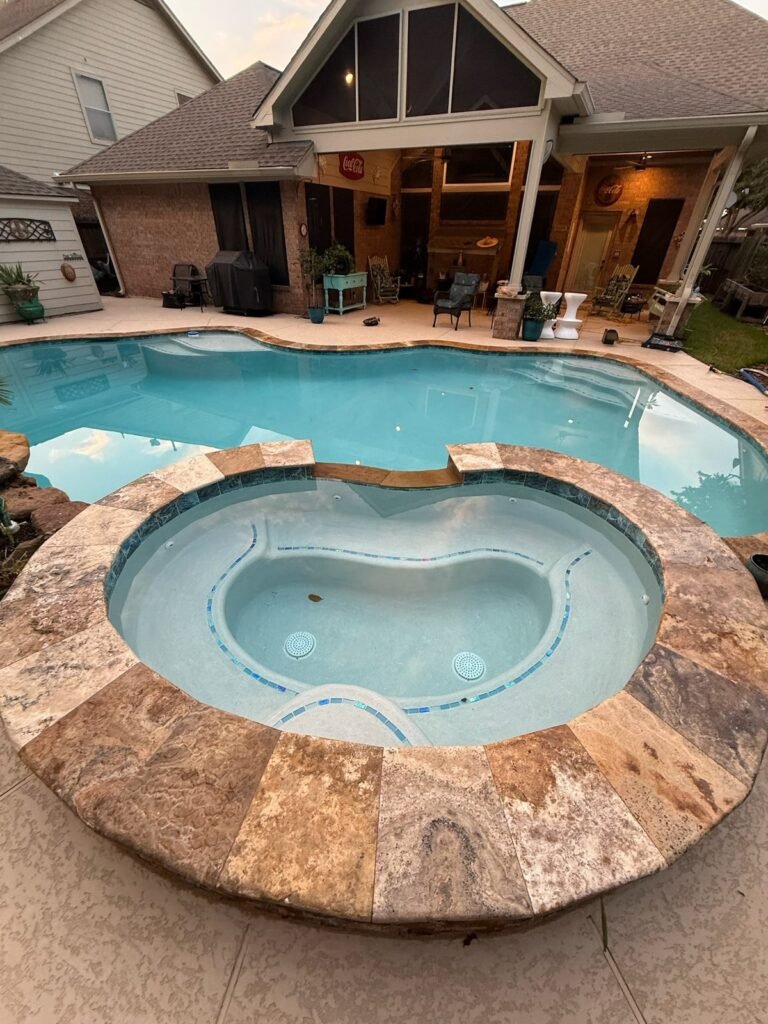 Pool with a large travertine spa at dusk