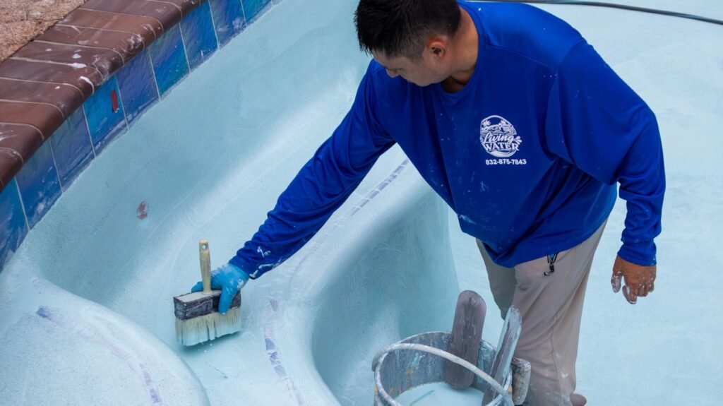 Living Water craftsman brushing the fresh finish at the waterline tile