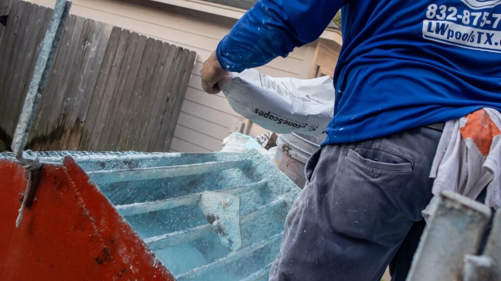 Living Water crew member pouring StoneScapes pool finish